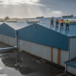 A warehouse roof being inspected after rain, symbolizing professional repair, durability, and protection from ongoing leaks.