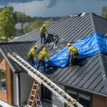 Roofers covering an exposed roof with tarps during sudden rain, demonstrating professional preparation and protection during a mid-project downpour.